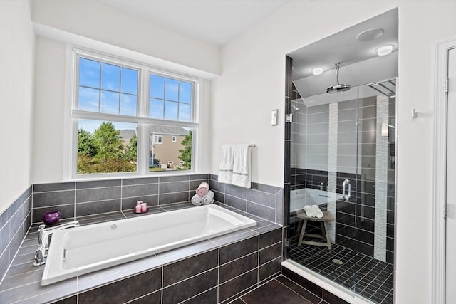 bathroom featuring a garden tub and a shower stall