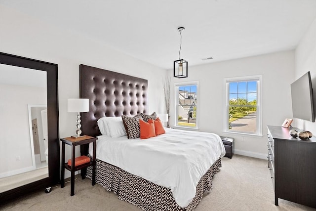 bedroom featuring baseboards, visible vents, and light colored carpet