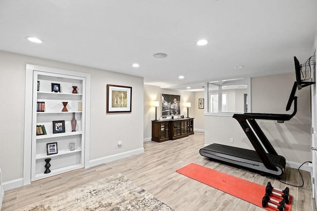 exercise room with recessed lighting, light wood-type flooring, built in shelves, and baseboards