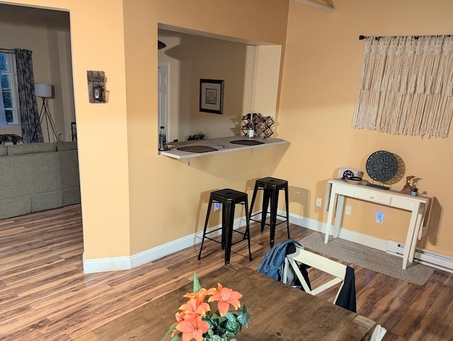 dining space with hardwood / wood-style flooring and a baseboard radiator