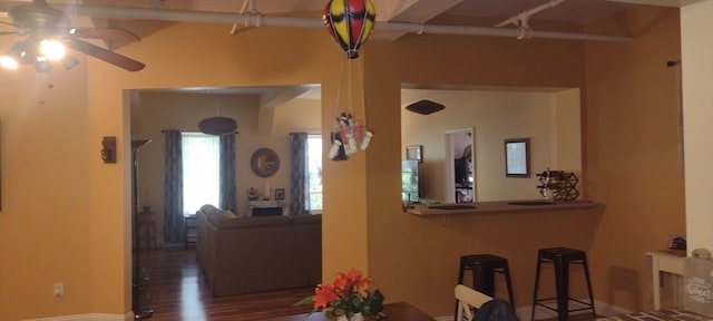 dining area with dark hardwood / wood-style floors, beamed ceiling, and ceiling fan