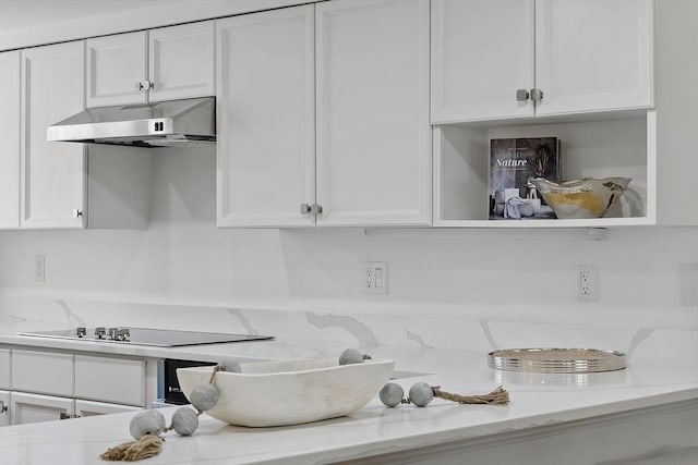 kitchen featuring black electric stovetop, light stone countertops, under cabinet range hood, and white cabinetry