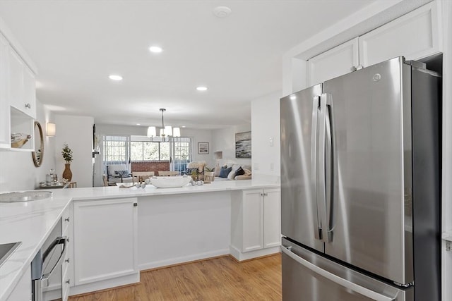 kitchen with freestanding refrigerator, white cabinetry, and light wood-style flooring