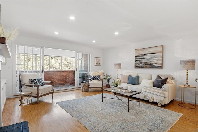 living area featuring baseboards, recessed lighting, and light wood-style flooring