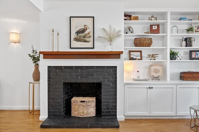 room details featuring baseboards, wood finished floors, and a fireplace