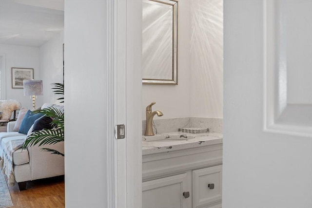 bathroom with vanity, ensuite bath, and wood finished floors