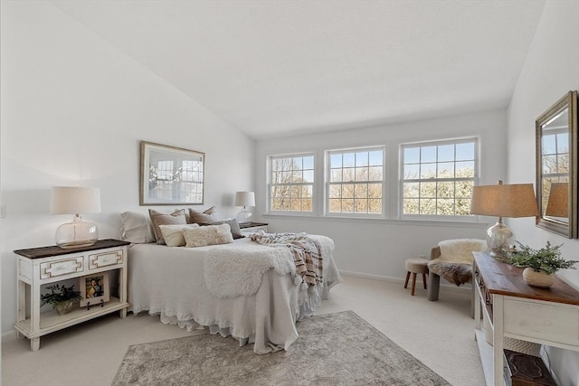 carpeted bedroom with baseboards, vaulted ceiling, and multiple windows