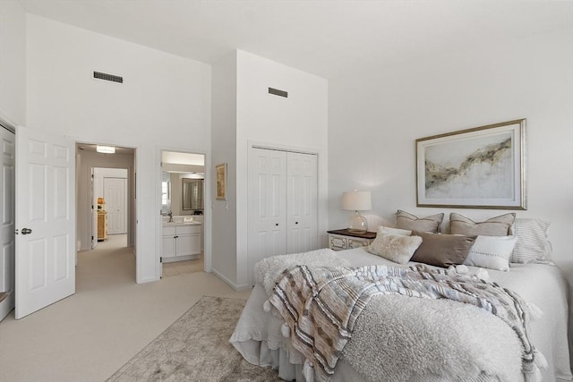bedroom with a sink, a towering ceiling, light carpet, and visible vents