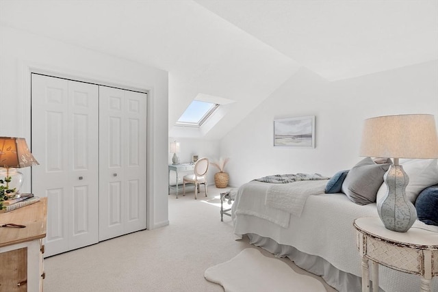 carpeted bedroom with lofted ceiling with skylight and a closet