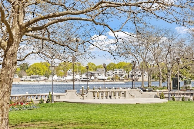 view of home's community featuring a lawn and a water view