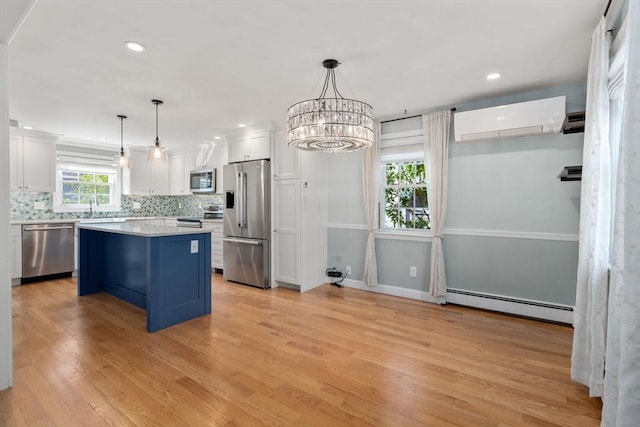 15 Janet Rd, Arlington, MA 02474 - kitchen with appliances with stainless steel finishes, a baseboard heating unit, a wall mounted AC, white cabinets, and tasteful backsplash