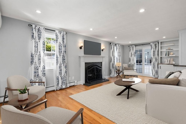 15 Janet Rd, Arlington, MA 02474 - living area featuring recessed lighting, a fireplace with raised hearth, light wood finished floors, a baseboard radiator, and a baseboard heating unit