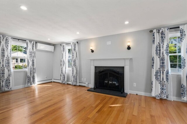 15 Janet Rd, Arlington, MA 02474 - unfurnished living room with an AC wall unit, light wood-style flooring, a fireplace, recessed lighting, and baseboards