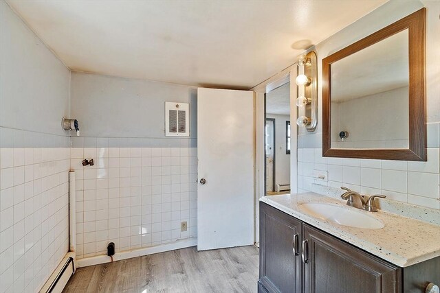 22 Taylor St Unit 1, Gloucester, MA 01930 - bathroom with tile walls, baseboard heating, vanity, and wood finished floors