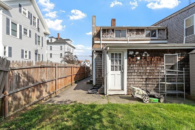 22 Taylor St Unit 1, Gloucester, MA 01930 - back of property featuring a fenced backyard, a trampoline, and a chimney