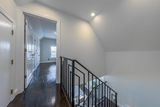 hallway with vaulted ceiling and dark hardwood / wood-style flooring