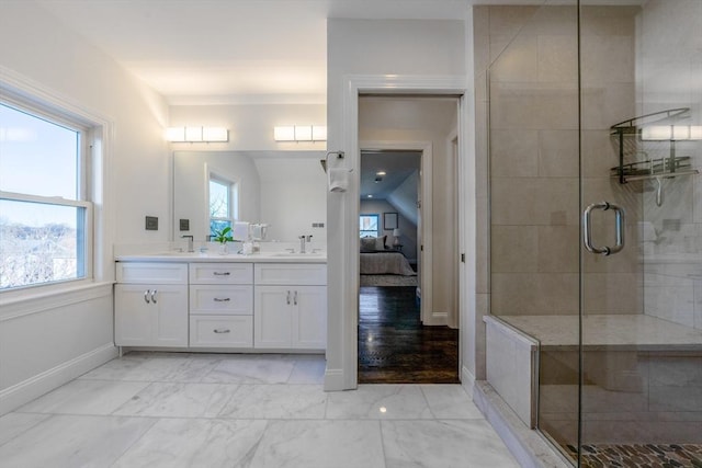 bathroom with vanity, a healthy amount of sunlight, and a shower with door