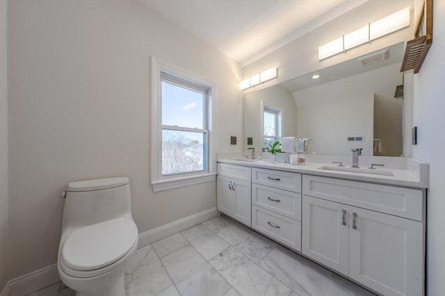 bathroom with toilet, vanity, and lofted ceiling