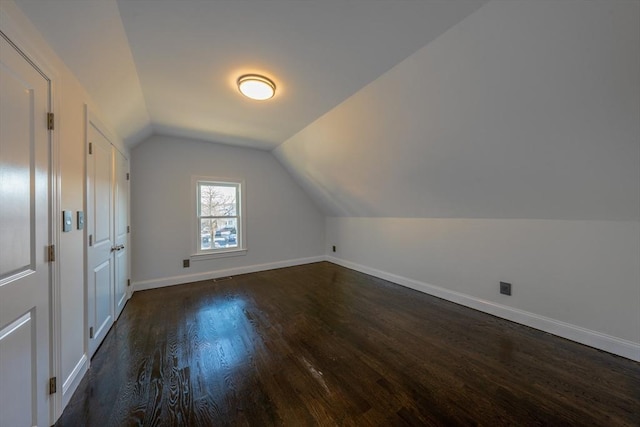 bonus room with lofted ceiling and dark hardwood / wood-style flooring