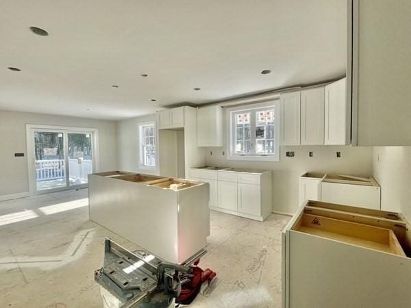 kitchen featuring a healthy amount of sunlight, white cabinets, and a kitchen island