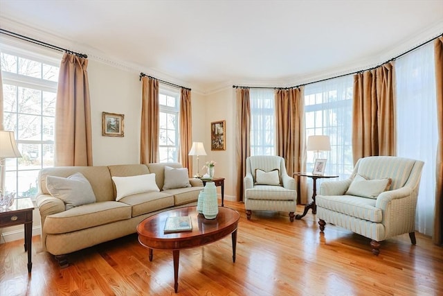 sitting room featuring crown molding, plenty of natural light, and light wood-type flooring