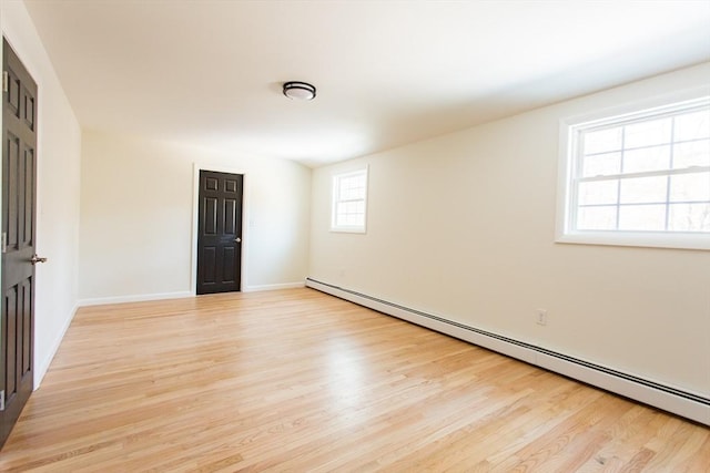 spare room featuring light wood-type flooring and a baseboard radiator