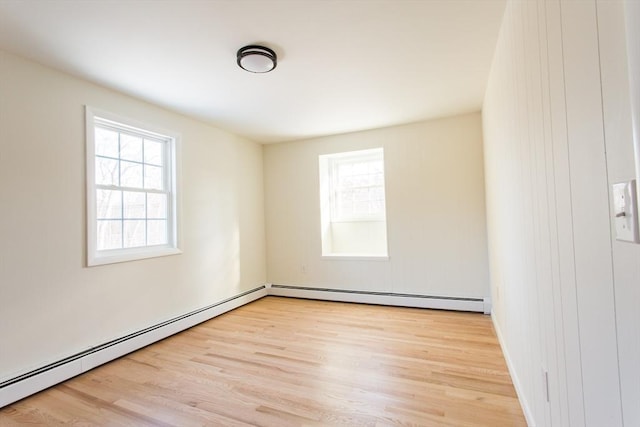 empty room featuring a baseboard radiator and light wood-type flooring