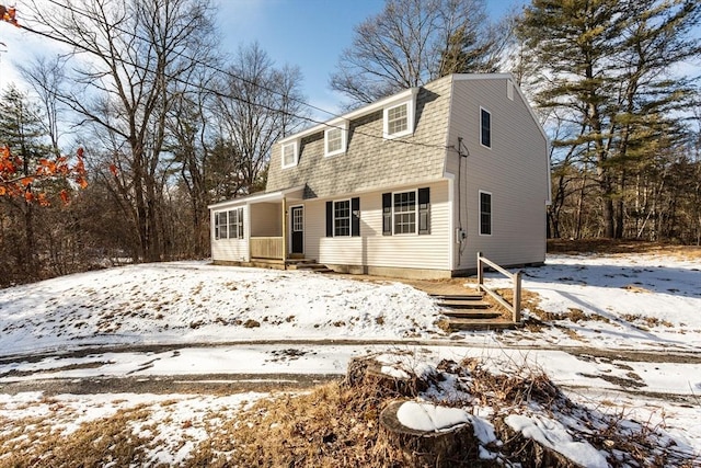 view of snow covered rear of property