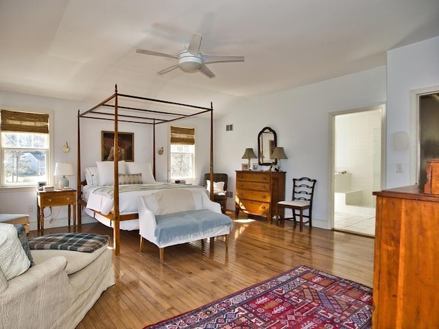 bedroom with visible vents, connected bathroom, and wood finished floors