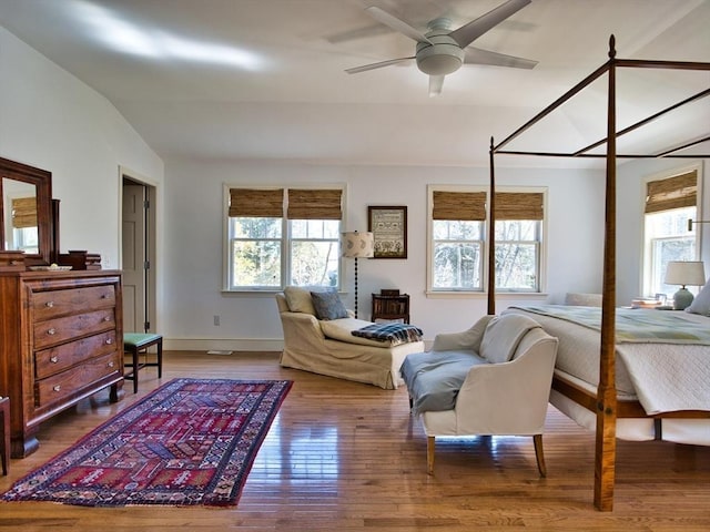 interior space with lofted ceiling, baseboards, a ceiling fan, and wood finished floors