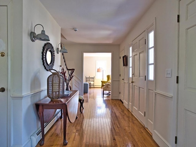 entryway with light wood-type flooring, stairway, and baseboard heating