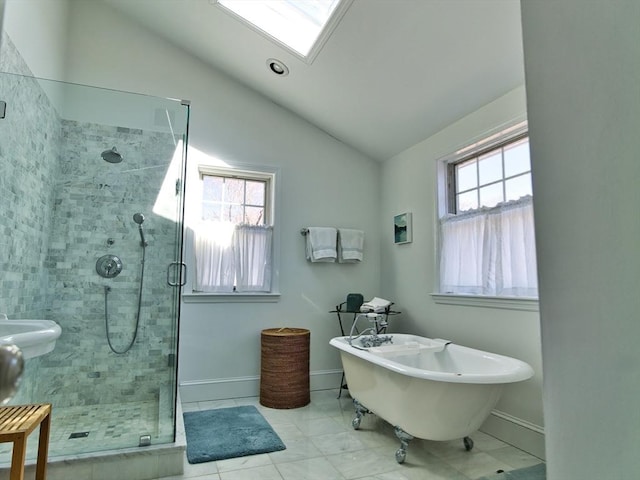 bathroom featuring baseboards, a healthy amount of sunlight, lofted ceiling with skylight, and a stall shower