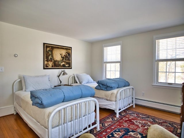 bedroom featuring dark wood-style floors and a baseboard radiator