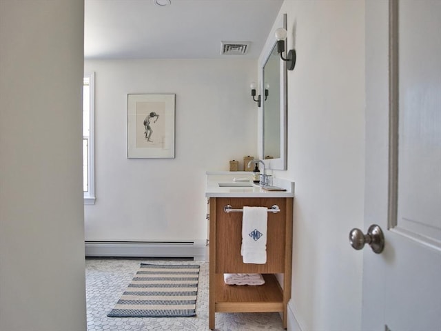 bathroom featuring baseboard heating, vanity, and visible vents