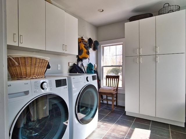 clothes washing area with cabinet space, dark tile patterned floors, and separate washer and dryer