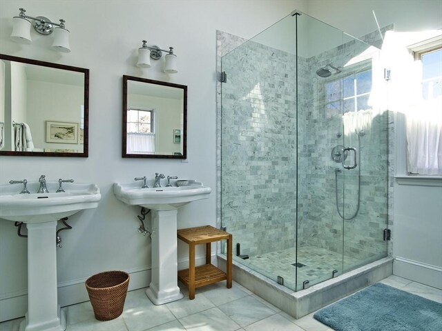 full bath with a stall shower, a sink, and baseboards