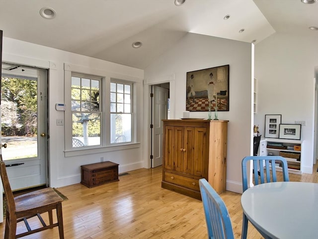 dining area with lofted ceiling, light wood-type flooring, and a healthy amount of sunlight