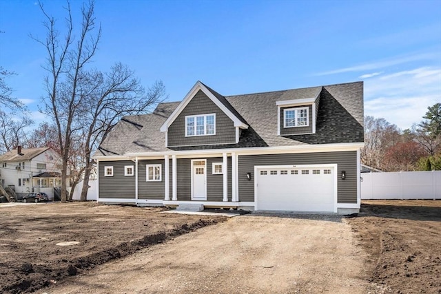 view of front facade with covered porch, fence, a shingled roof, dirt driveway, and an attached garage