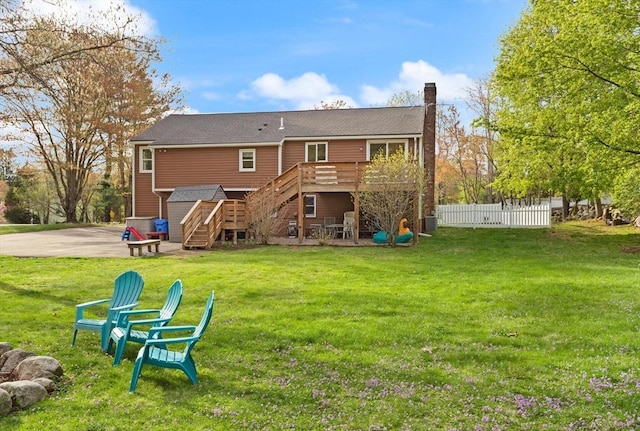 back of property featuring a wooden deck, fence, a chimney, central AC unit, and stairway