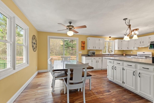 kitchen with plenty of natural light, stainless steel microwave, and white range with gas stovetop
