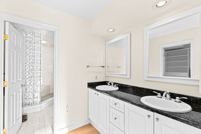 bathroom featuring vanity, tile patterned floors, and a tile shower