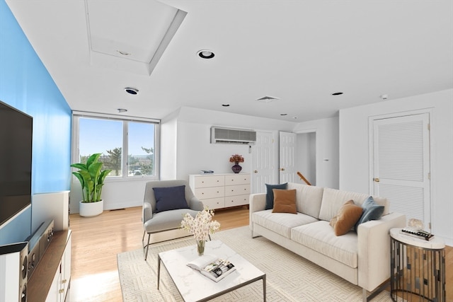 living room with light wood-type flooring and a wall mounted AC