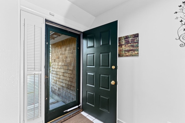 interior space with vaulted ceiling and light tile patterned floors