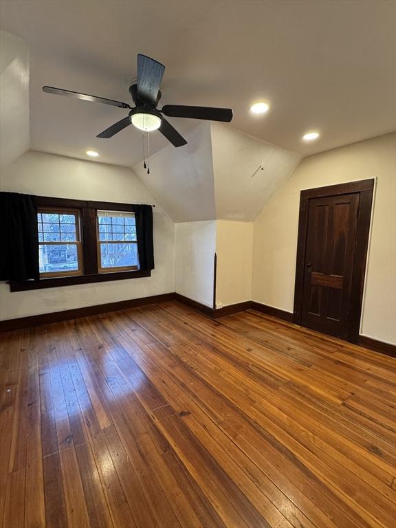 additional living space with hardwood / wood-style flooring, ceiling fan, and vaulted ceiling