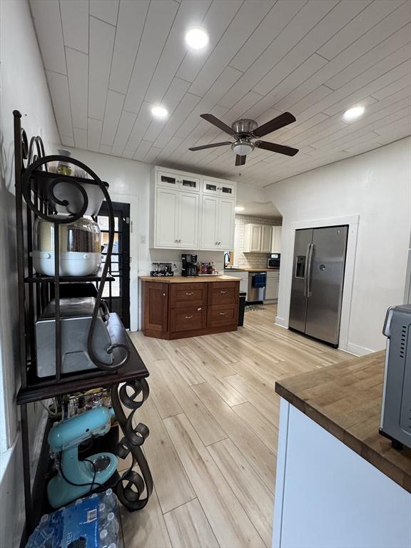 kitchen with light hardwood / wood-style floors, stainless steel appliances, ceiling fan, dark brown cabinetry, and white cabinets