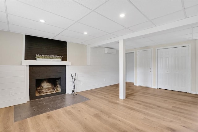 216 Pineview Cir, Agawam, MA 01001 - unfurnished living room featuring wood finished floors, a wall unit AC, a fireplace, a drop ceiling, and recessed lighting