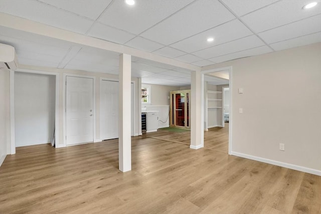 216 Pineview Cir, Agawam, MA 01001 - below grade area featuring a wall unit AC, light wood-type flooring, baseboards, recessed lighting, and a paneled ceiling