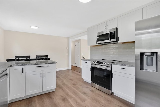 216 Pineview Cir, Agawam, MA 01001 - kitchen with appliances with stainless steel finishes, light wood-style floors, white cabinetry, backsplash, and light stone countertops