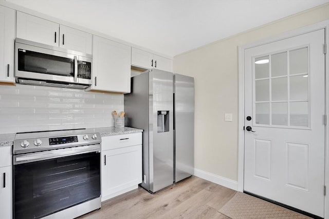 216 Pineview Cir, Agawam, MA 01001 - kitchen featuring appliances with stainless steel finishes, light wood finished floors, white cabinets, and backsplash