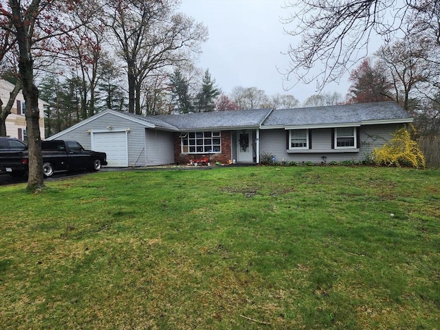 ranch-style home with an attached garage, a front lawn, and aphalt driveway